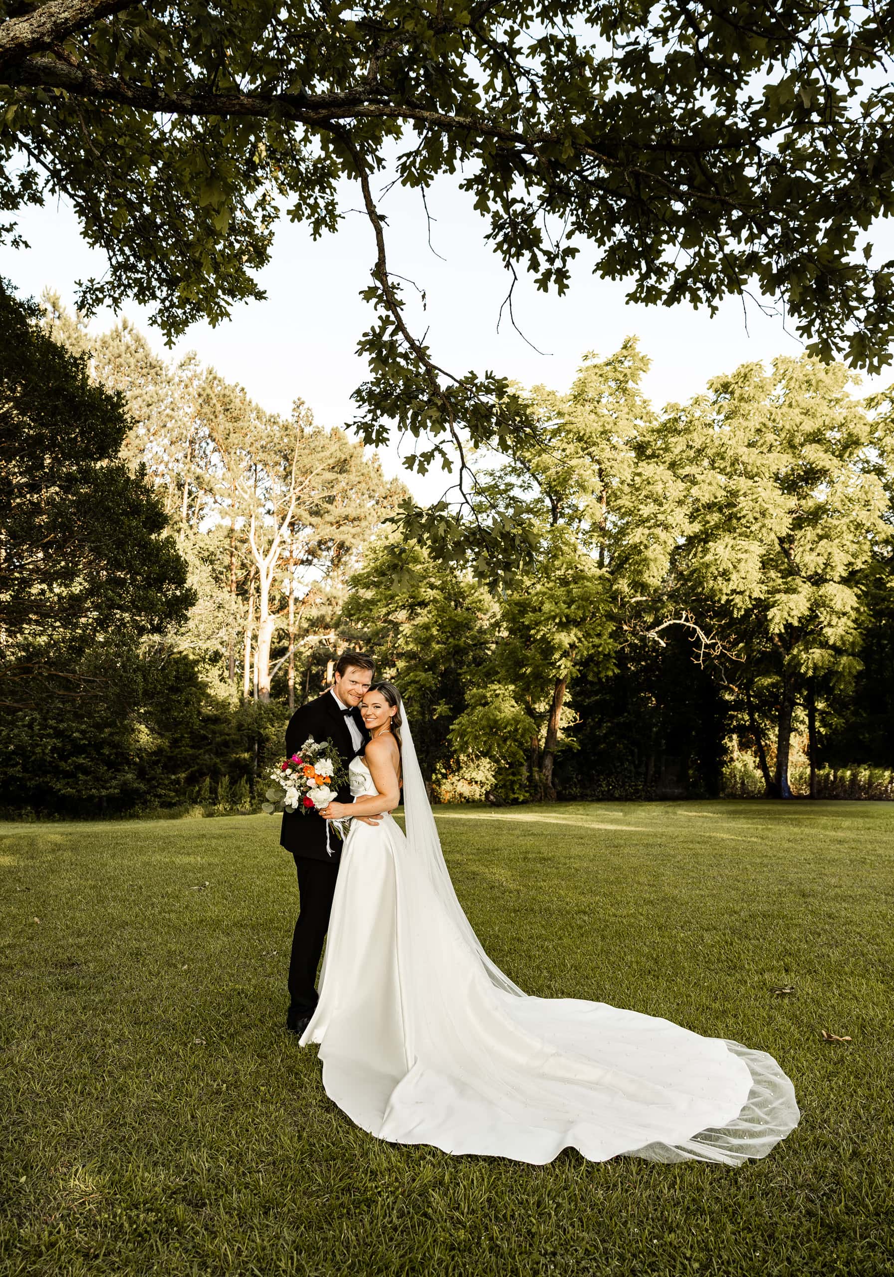 Andrew and Alyssa standing side by side like a family, holding each other with calm affection in a timeless, elegant portrait.