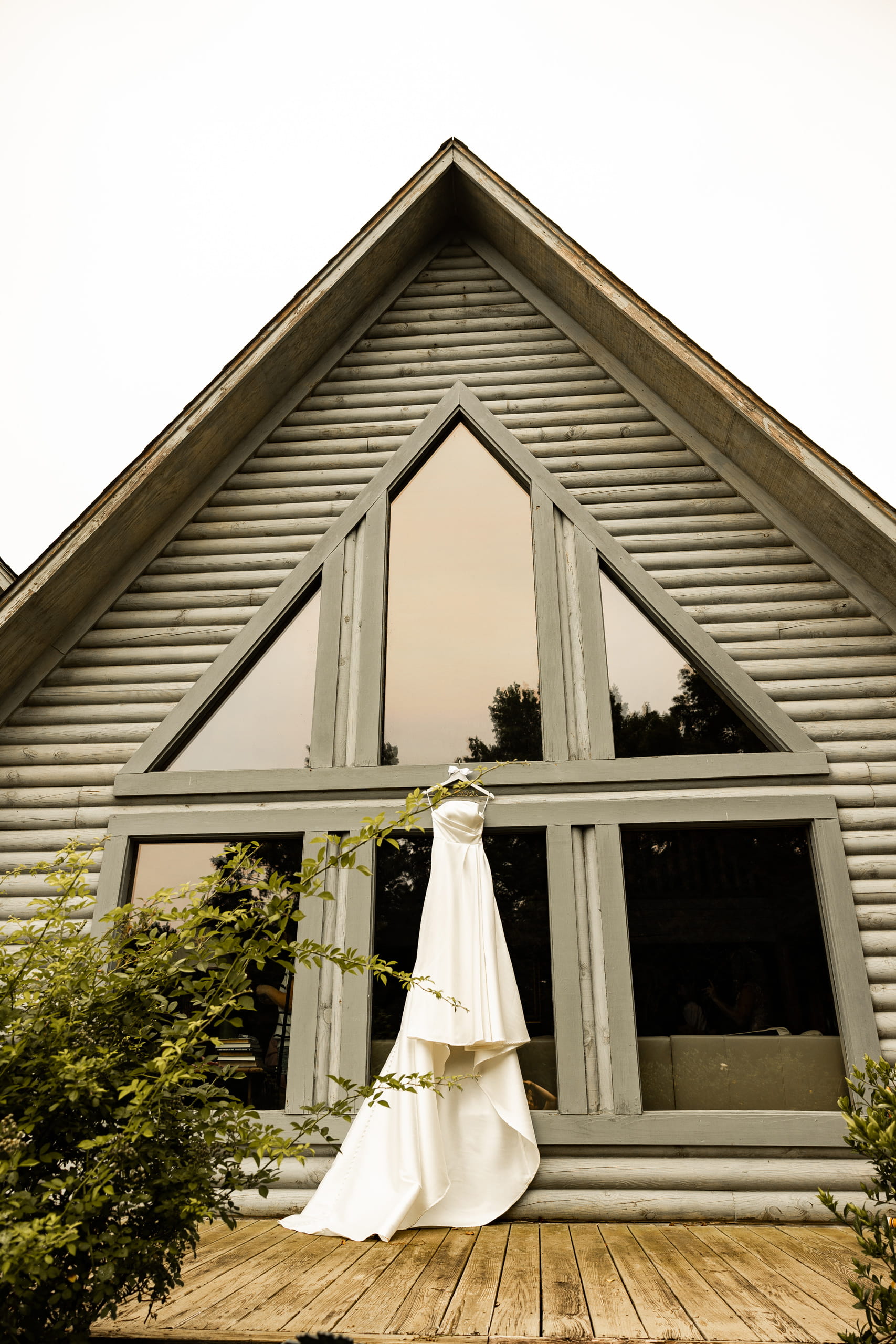 Bridal wedding dress hanging in front of the bride’s house, captured in natural light as part of the wedding day details.