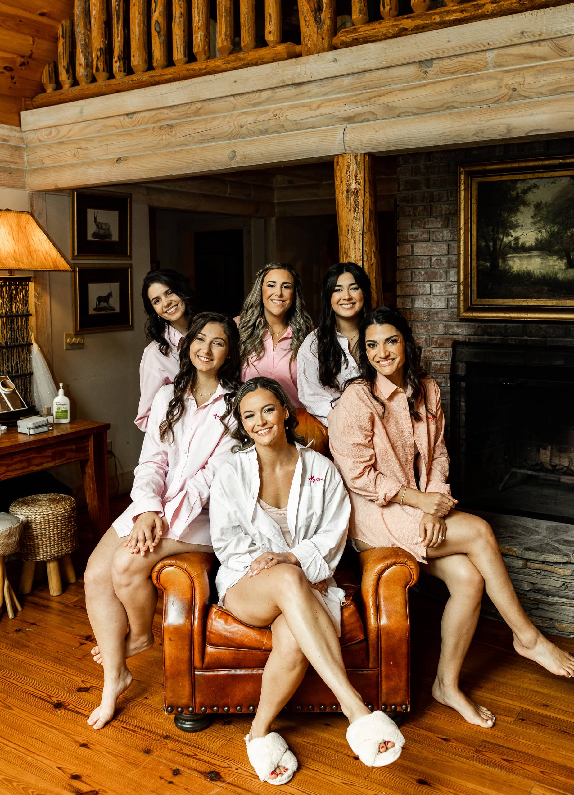 Bridesmaids in pyjamas gathered around the bride, smiling and sharing a joyful moment before getting dressed for the wedding.