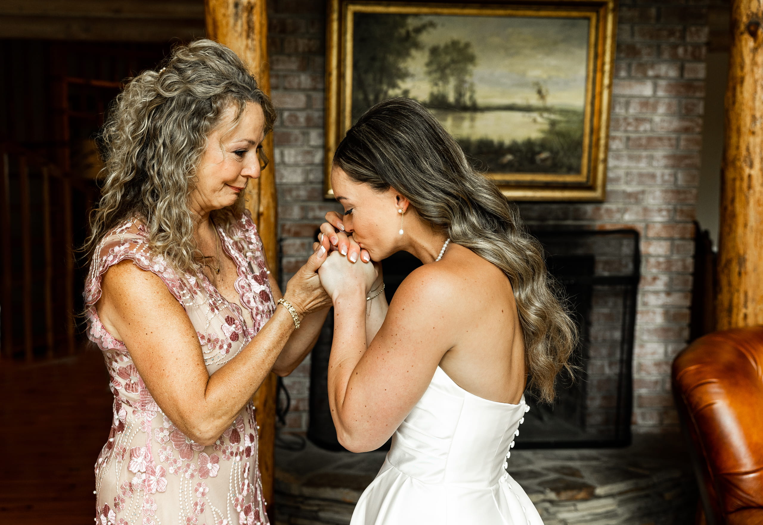 Touching wedding photo of the bride kissing her mother’s hands, symbolizing love, gratitude, and family connection.