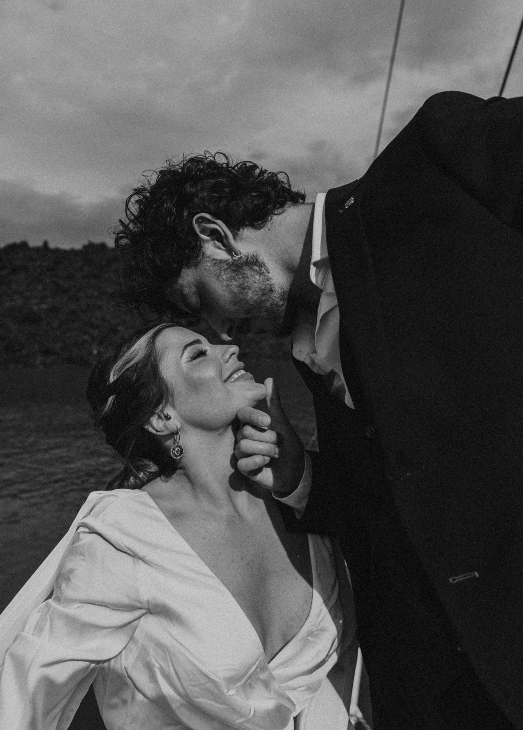 Black and white image of Matty gently approaching Jeannie for a kiss, capturing intimacy and emotion during their Santorini elopement.