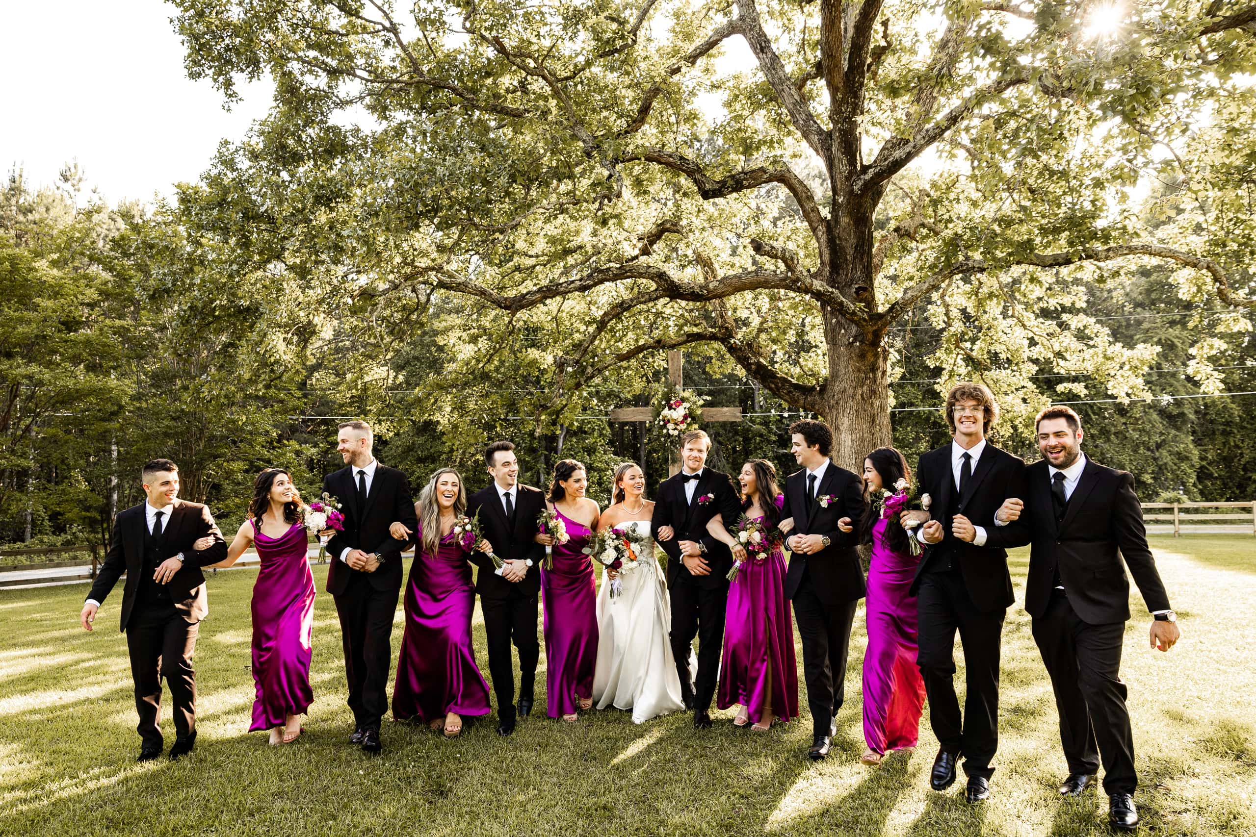 Alyssa and Andrew surrounded by their bridesmaids and groomsmen, captured in an elegant outdoor wedding group photo filled with happiness.